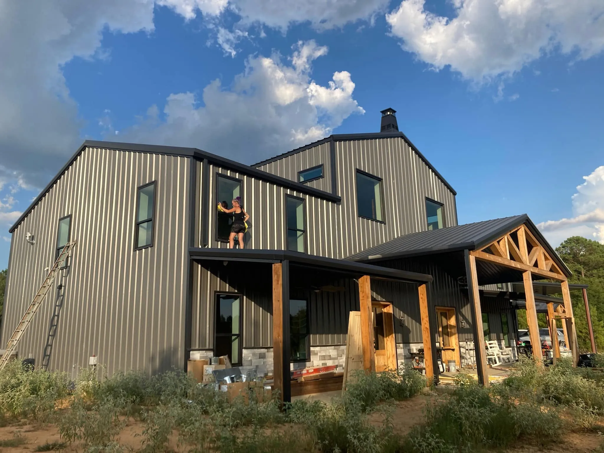 Out of the Ashes Cleaning Services team member detail-cleaning an exterior window on a new construction home in East Texas